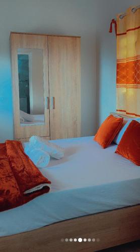 a bedroom with a large white bed with orange pillows at Lacazavanoo in Baillif