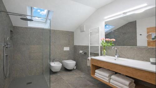 a bathroom with a sink and a toilet and a mirror at Binterhof Alpin Deluxe APP in Castelrotto