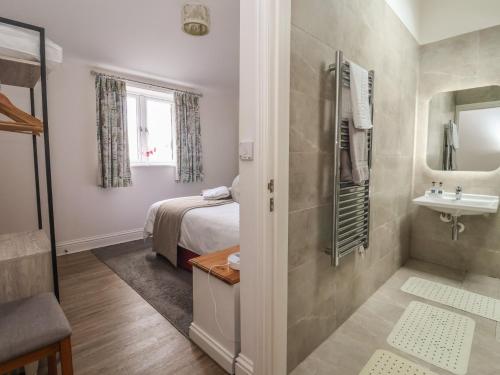 a bedroom with a bed and a bathroom with a sink at Shepherd's Crook in Harrogate