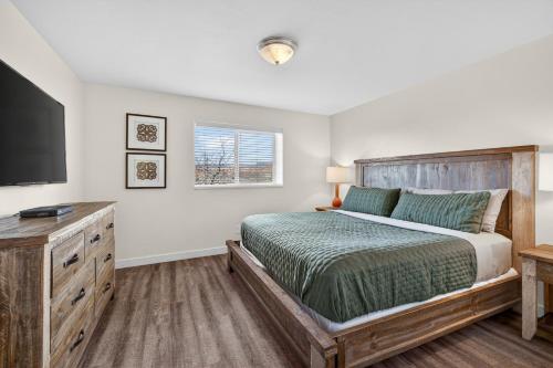 a bedroom with a bed and a flat screen tv at Moab RedCliff Condos in Moab