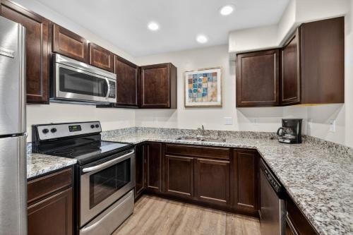 a kitchen with wooden cabinets and stainless steel appliances at Moab RedCliff Condos in Moab