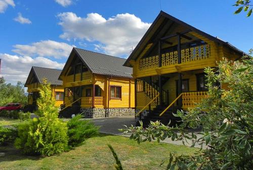 una gran casa amarilla con techo de gambrel en Hotel and restaurant complex Skolmo, en Klevanʼ