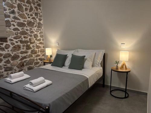 a bedroom with a large bed with towels on it at Amara Centro Luxury Apartments in Mouzaki