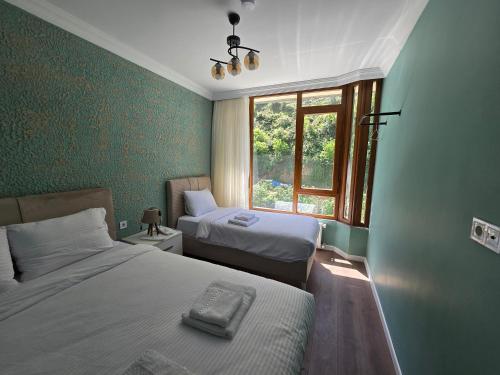 a hotel room with two beds and a window at ESLA Suites in Çamlıhemşin