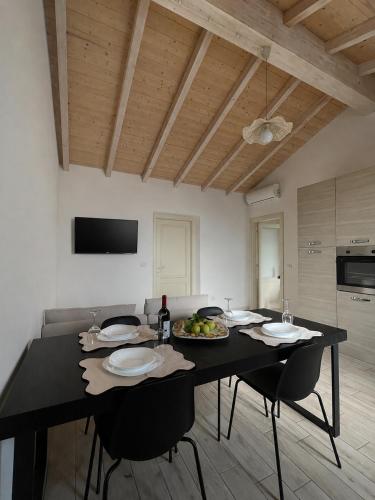 a dining room with a black table with chairs and a tableablish at Casa vacanze indipendente in Follonica