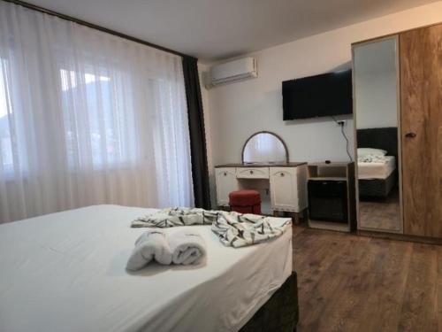 a hotel room with a bed with towels on it at Hotel Boheme in Peje