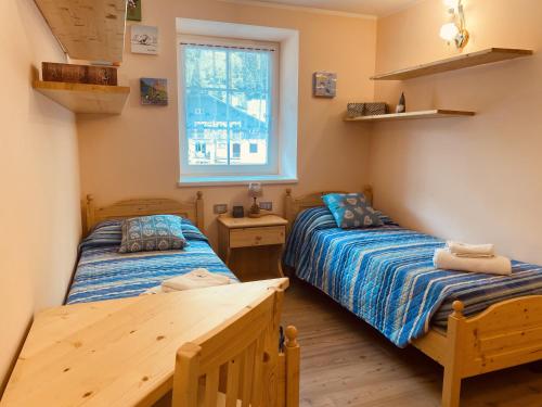 a bedroom with two beds and a window at My sweet home in the Dolomites - Appartamento LatteMiele in Predazzo