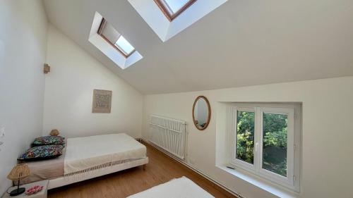 a bedroom with a bed and a mirror and a window at L'Autre Paradis-Piscines naturelles-Plages-Jardin enchanté-Sauna in Poligny