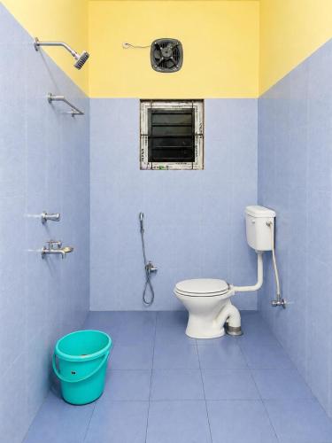 a bathroom with a toilet and a bucket at Moonleaf Stay, Guwahati in Guwahati