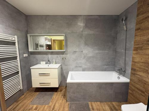 a bathroom with a white tub and a sink at Belvedere Luxury Suite in Bojnice