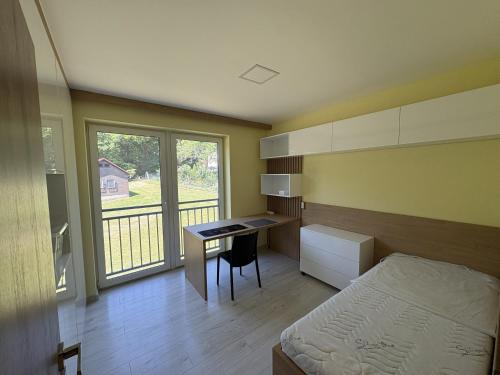 a bedroom with a bed and a desk and a bed and a window at Belvedere Luxury Suite in Bojnice