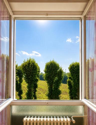 an open window with a view of a field at Room between Milan and Como in Seregno