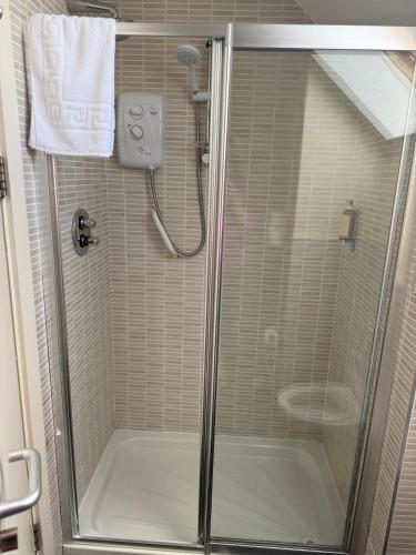 a shower with a glass door in a bathroom at Large four bedroom town centre house in Killarney