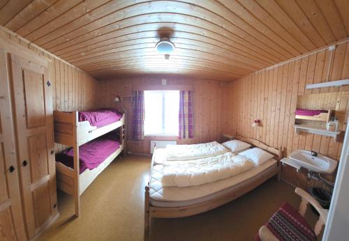 a bedroom with a large bed in a wooden room at Lauvåsen Rooms Langleiken in Sør-Fron