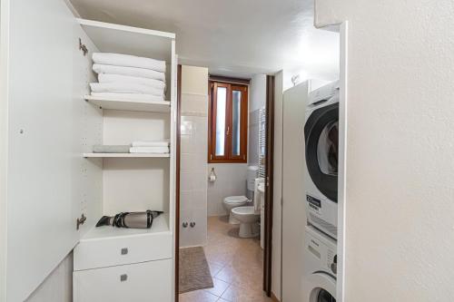 a white bathroom with a washer and dryer in it at My Tiny Home Venice in Marghera