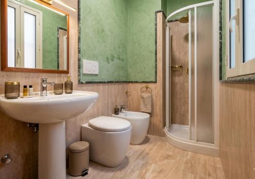 a bathroom with a sink and a toilet and a shower at Appartamenti in Villa Polimnia in Fontane Bianche