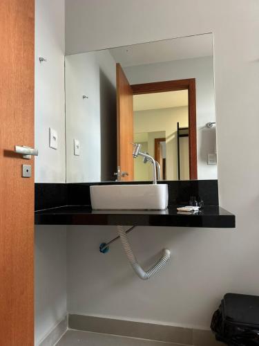 a bathroom with a sink and a mirror at Piúma Palace Hotel in Piúma