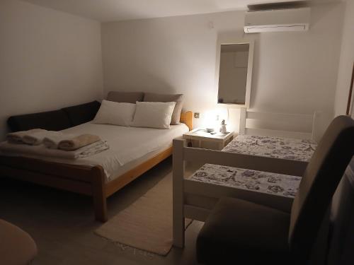 a small bedroom with a bed and a couch at Apartman Bukulja in Arandelovac