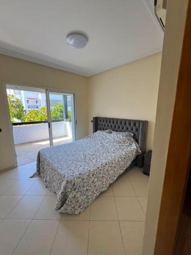 a bedroom with a bed and a large window at Marina golf A in Asilah