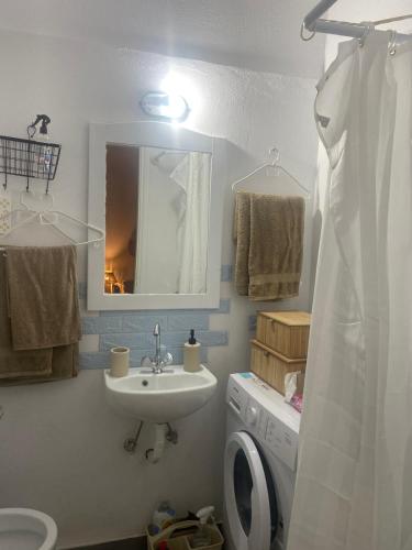 a bathroom with a sink and a washing machine at Studio DKMK in Malia