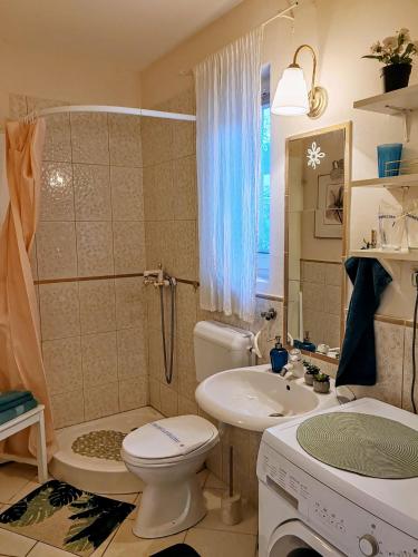 a bathroom with a toilet and a sink and a tub at Inner Harmony Garden in Kanjiža