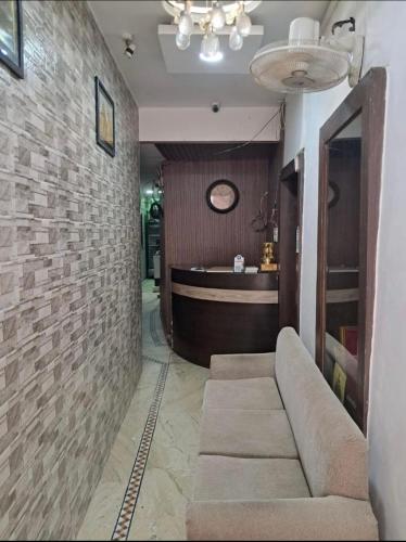 a lobby with a couch against a brick wall at Alaknanda lodge in Varanasi