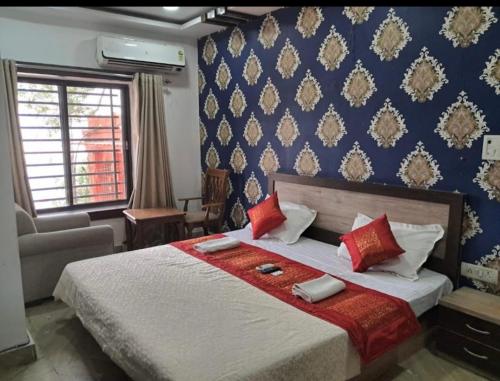a bedroom with a large bed and a blue wall at Alaknanda lodge in Varanasi