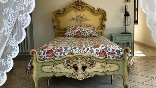 a bedroom with a bed with a floral bedspread at Casa Didavani 2-6 people in Belveglio