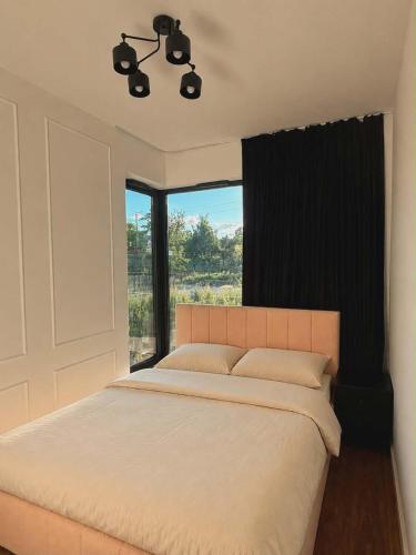 a bedroom with a large bed with a large window at MC Residence Łomża in Łomża