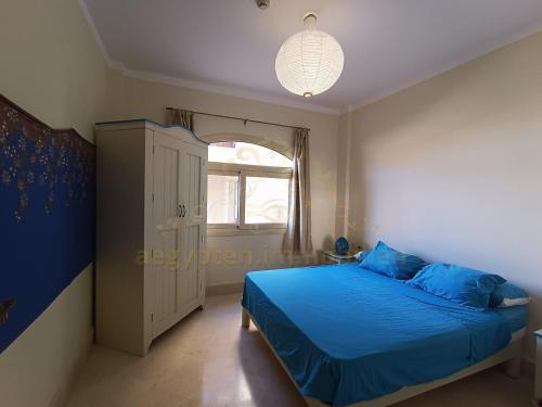 a bedroom with a blue bed and a window at OrientalCoast Marsa Alam Private Beach in Quseir