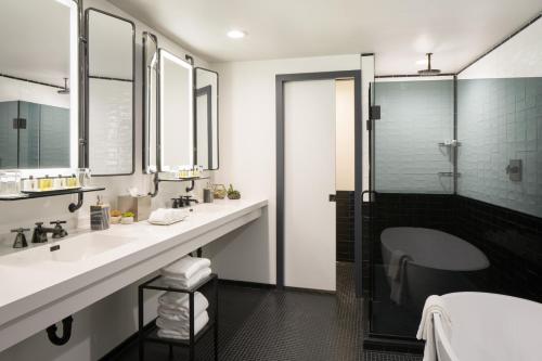 a bathroom with two sinks and a shower at Thompson Seattle, by Hyatt in Seattle