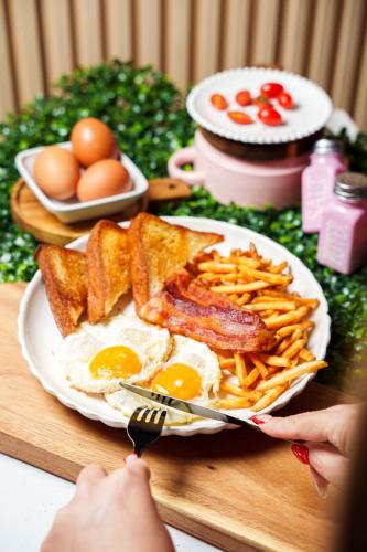 a plate of breakfast food with eggs and french fries at D'Ponke Guest House in Cayey