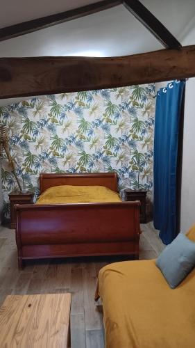 a bedroom with two beds in a room with a wall at Gite bleu in Aizenay