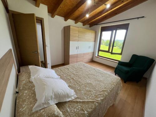 a bedroom with a bed and a chair and a window at Casa CABAÑA in Riaño