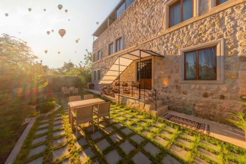 a building with a patio and a yard at Cappadocia Tughan Stone House in Uçhisar