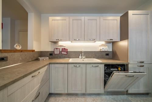 a kitchen with white cabinets and a sink at Casa Gradita in Ponte Caffaro