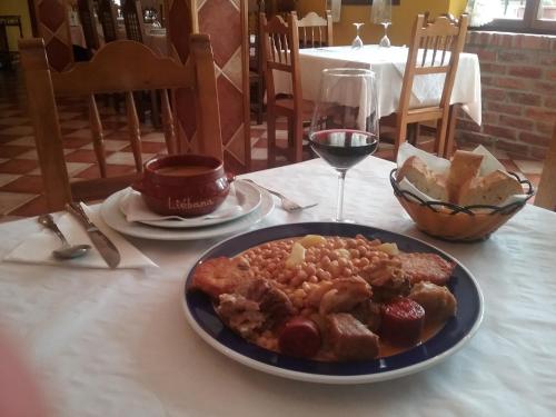 a plate of food on a table with a glass of wine at Posada Sobrevilla in Espinama