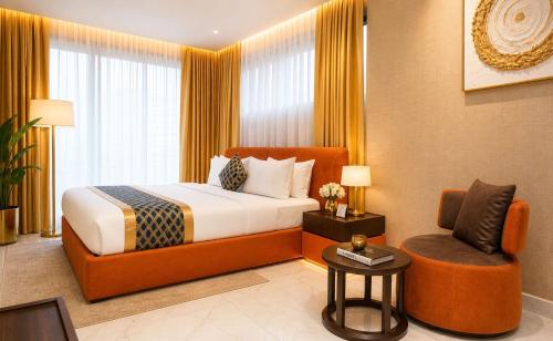 a hotel room with a bed and a chair at The Vynyard, Accra in Accra