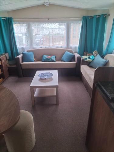 a living room with a couch and a table at Seaside Stay in Camber