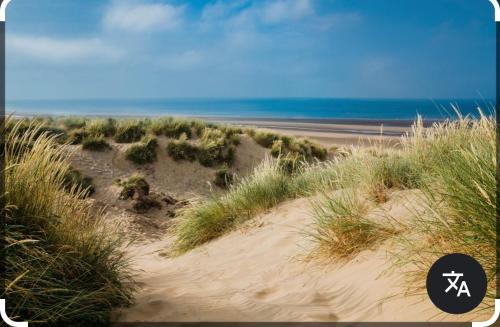a sandy beach with the ocean in the background at Seaside Stay in Camber