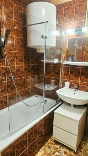 a bathroom with a shower and a sink and a tub at Fonyódi Süllő Garzon in Fonyód