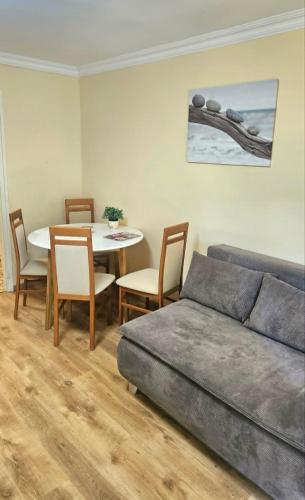 a living room with a couch and a table with chairs at Fonyódi Süllő Garzon in Fonyód
