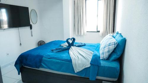 a blue bed in a room with a window at Smart Flat Apart in Mogi das Cruzes