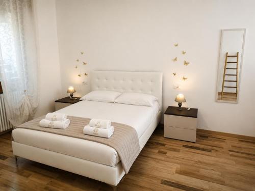 a bedroom with a large white bed with two towels at Dudi Jolie Maison - Jacuzzi in Lezzeno