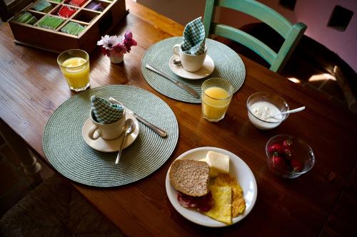a wooden table with plates of food and glasses of orange juice at Agriturismo Giandriale in Tavarone