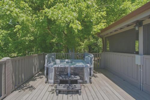 a hot tub on the deck of a house at Charming Mtn View Cabin Sleeps 8 Spacious Deck in Townsend
