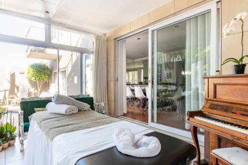 a room with a piano and a bed and a window at Your homely experience in Paarl