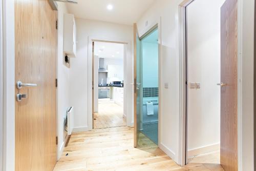 a hallway with a door leading to a kitchen at Watford Centre - Spacious Penthouse in Watford