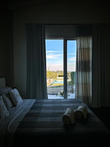 a bedroom with a large bed with a large window at Villa Mida in Calatabiano