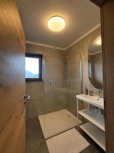 a bathroom with a shower and a glass door at Sonnenburg Hotel in Ehrwald